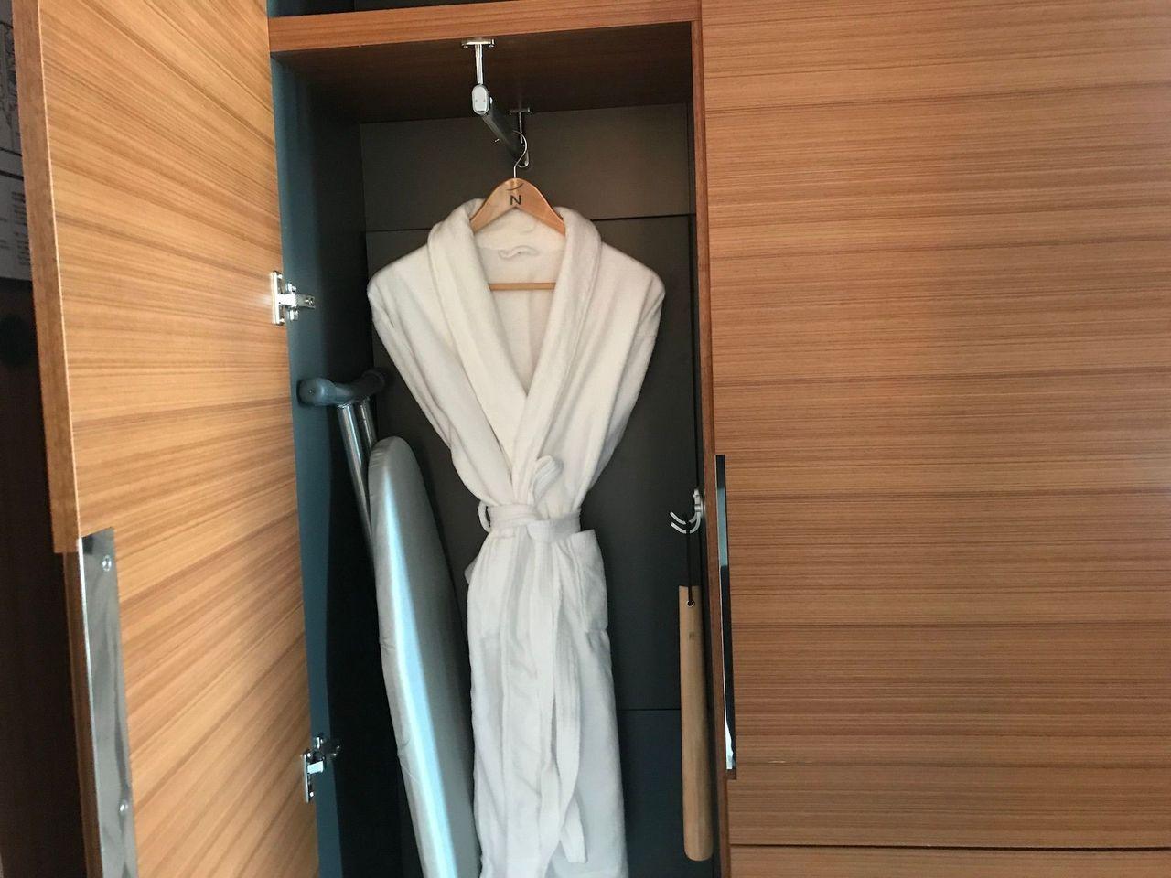 Wardrobe with a plush bathrobe and iron in the room of Dongdaemun Novotel Ambassador Hotel.